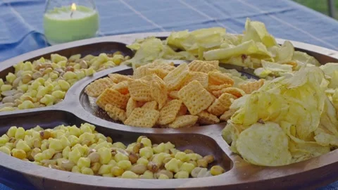 Close-up of Snack Platter with Chips and Cereal Outdoors on Blue Tablecloth Stock Footage 342578918