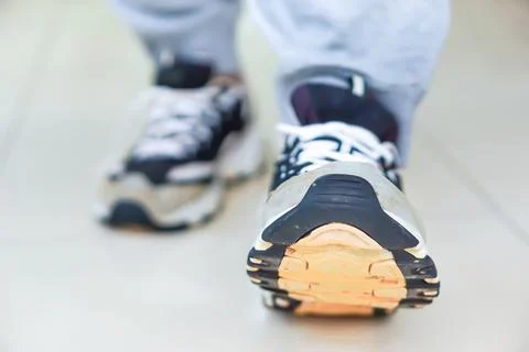 A close-up of a sneaker stepping forward on a smooth surface, showcasing mo.. Stock Photos