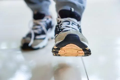 A close-up of a sneaker stepping forward on a smooth surface, showcasing mo.. Stock Photos