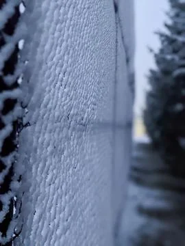 Close Up of Snow Covered Chain Link Fence in Winter Fotos de archivo