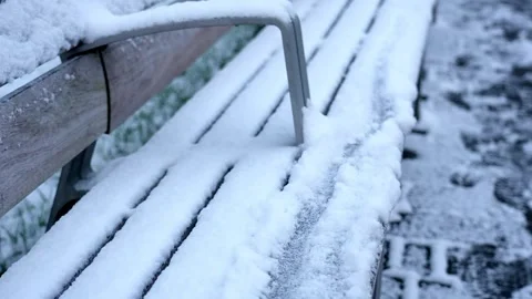 Close-Up of Snow-Dusted Park Bench in Winter Stock Footage 256528324