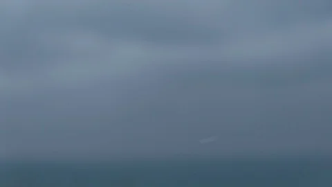 Close-up of snow flakes flying into camera with blurred blue sky in background Stock Footage 101472879