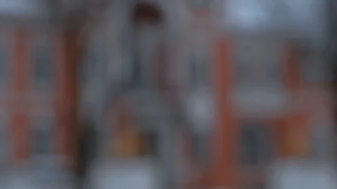 Close-up of snow flakes flying into camera with blurred building in background Stock Footage 101472894