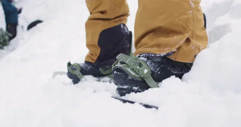 Close Up on Snowboard Bindings As Snowboarder Gets Ready to Ride Down the Ski Stock Footage 142295818