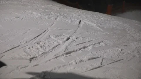 Close-up of snowboarders sliding down a mountain in the evening Stock Footage 124006882