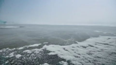 Close-up of snowflakes flapping in the wind on the ice surface, storm and Stock Footage 234134834