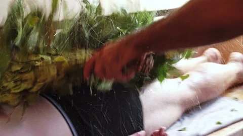 Close-up of soaking a bath broom in a metal basin. Bath juniper broom Stock Footage 223881492