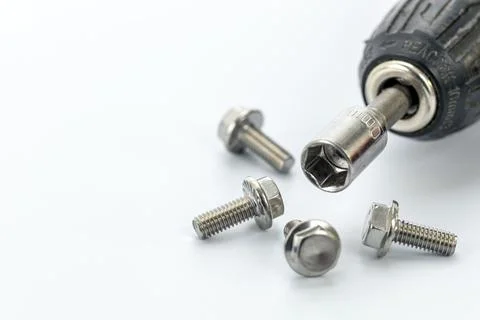 Close-up of a socket wrench attached to a drill surrounded by shiny steel b.. Stock Photos