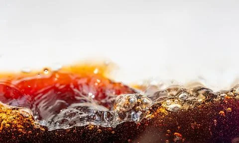 Close-up of soda splash with bubbles and dark liquid Stock Photos