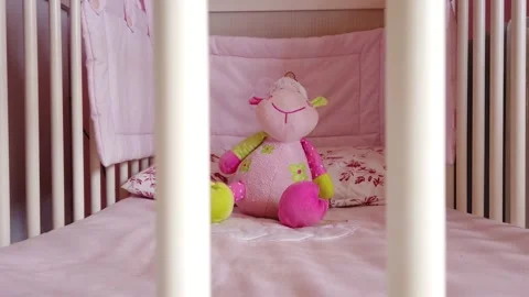 Close up of a soft bear toy at white children's bed. baby cot Stock Footage 148411084