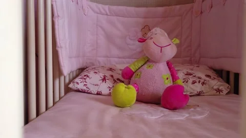 Close up of a soft bear toy at white children's bed. baby cot Stock Footage 148411121