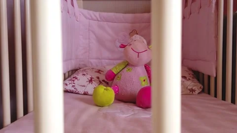 Close up of a soft bear toy at white children's bed. baby cot Stock Footage 148411122