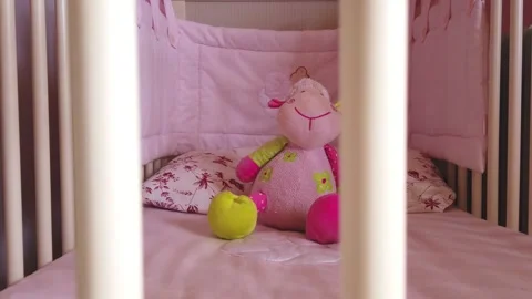 Close up of a soft bear toy at white children's bed. baby cot Stock Footage 148411144