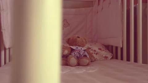Close up of a soft bear toy at white children's bed. baby cot Stock Footage 148411153