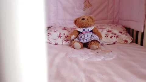 Close up of a soft bear toy at white children's bed. baby cot Stock Footage 148411174