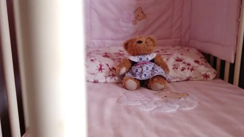 Close up of a soft bear toy at white children's bed. baby cot Stock Footage 148411188