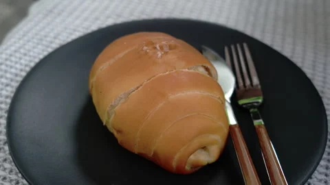Close Up Soft Bread Roll Served on Black Plate with Knife and Fork Stock Footage 329677689