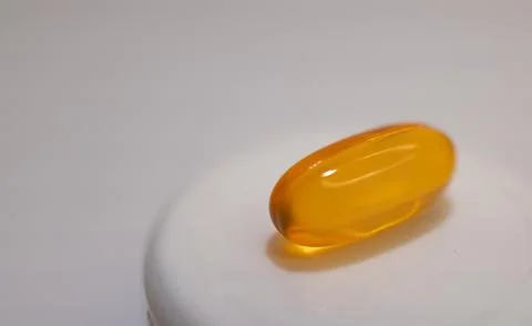 Close-up of soft capsule of vitamins on light background. Stock Photos