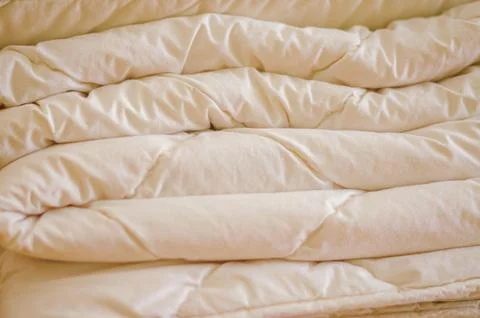 Close-up of a soft, fluffy folded white blanket with satin-like texture Stock Photos
