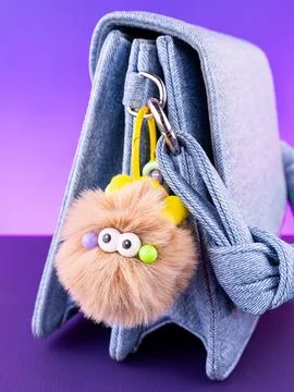 Close-up of a soft, fluffy plush keychain in the shape of a brown monster wit Foto stock