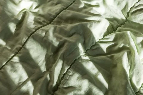 Close-up of a soft green comforter with quilted stitching Foto stock