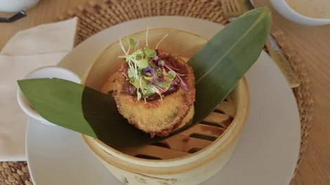 Close-up soft movement of panko-battered avocado appetizer in bamboo steamer Video stock 321193304