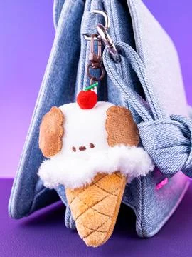 Close-up of a soft plush keychain in the shape of a puppy with an ice cream o Foto stock