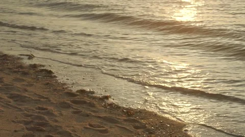 Close up of soft waves hitting the sand during sunset 스톡 동영상 64830344