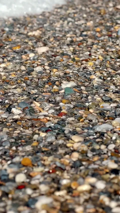 Close-up . soft waves, with white foam are washed ashore, on pebble beach. Stock Footage 319389927