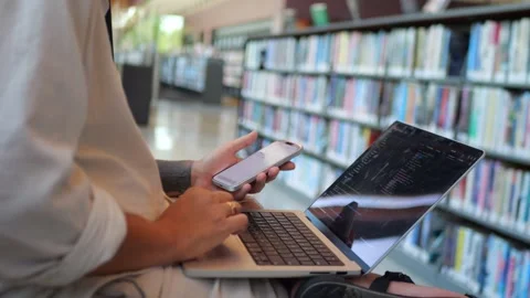 Close-Up of Software Developer Typing Code on Laptop in Library... Stock Footage 334437003