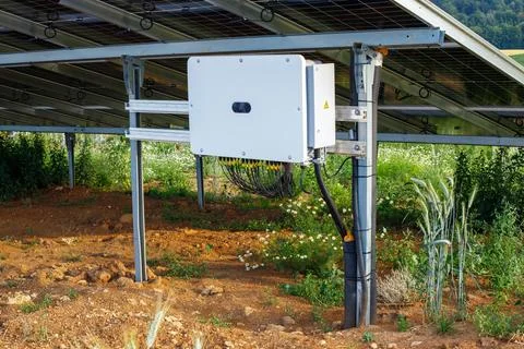 Close-up of a solar inverter box installed under photovoltaic panels on a sol Stock Photos