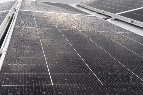 Close-up of a solar panel surface covered with fresh rain droplets. Stock Photos