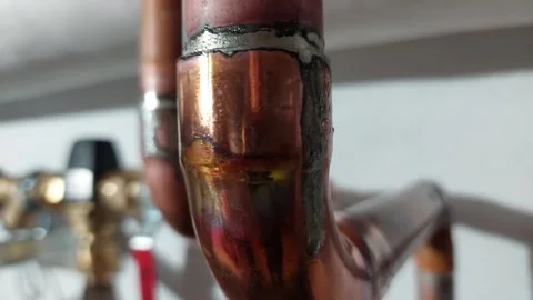 Close up of soldered copper pipe elbow in domestic heating or water system Vídeos de archivo 336561702