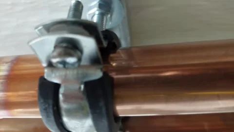 Close-up of soldered copper pipe with metal bracket installation Stock Footage 336945739