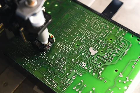 Close up of soldering process. Dispenser machine putting solder onto surface of Stock Photos