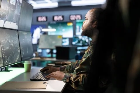 Close up of soldier analyzing military intelligence data on monitors Stock Photos