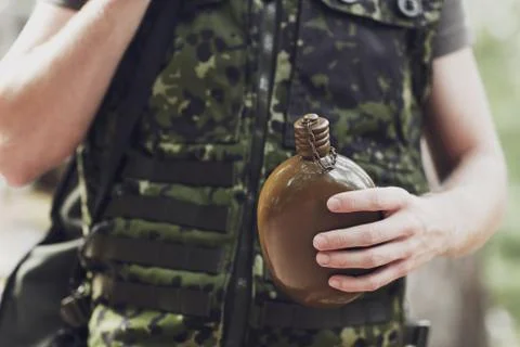Close up of soldier with gun and flask in forest Stock Photos
