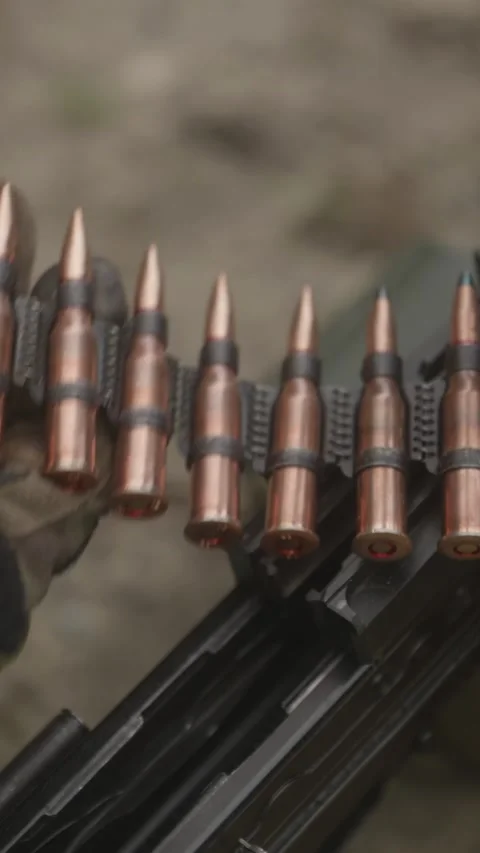 Close up of soldier hands loading ammunition belt for machine gun Stock Footage 333612676
