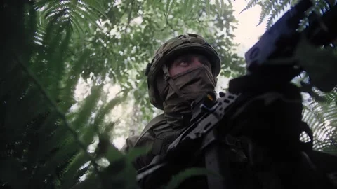 Close-up, a soldier sits in ambush in a dense deciduous forest Stock Footage 327350751