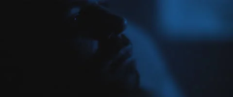 Close up of a soldier sitting alone in a dark room, staring to nowhere, deali Stock Footage 147543179