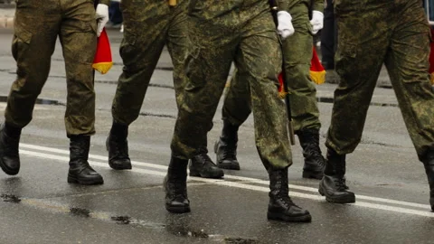 Close-up of soldiers marching in formation during a military parade on a wet Video stock 335261782