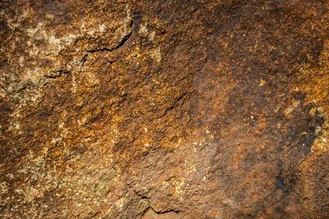 Close up of a solid granite rock in a variety of yellow and brown shades Stockfoto's