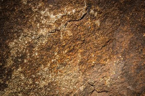 Close up of a solid granite rock in a variety of yellow and brown shades Stock Photos