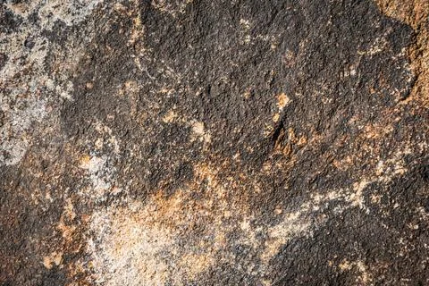 Close up of a solid granite rock in a variety of yellow and brown shades 스톡 사진