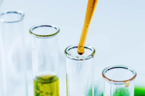 Close-up of solution dripping from a pipette into a laboratory test tube Fotos de archivo