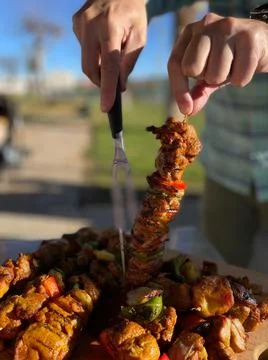 Close-up of some hands preparing meat skewers prepared on a barbecue Stock Photos