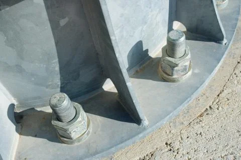 Close up of some larger screws into the base of a metal pillar Stock Photos