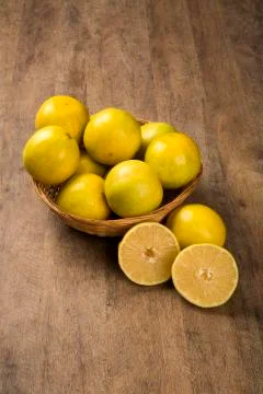 Close up of some oranges in a basket over a wooden surface Stock Photos