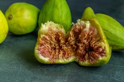 Close up of some raw fig fruit opened on a dark grunge surfaces Foto stock