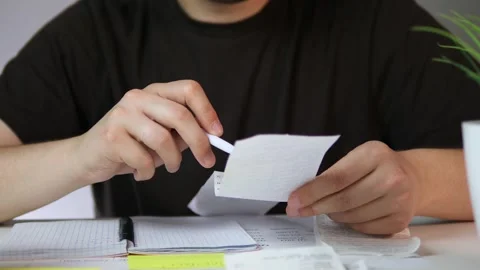 Close-up of someone analyzing a sales receipt with a pen, underlining key Video stock 316584718